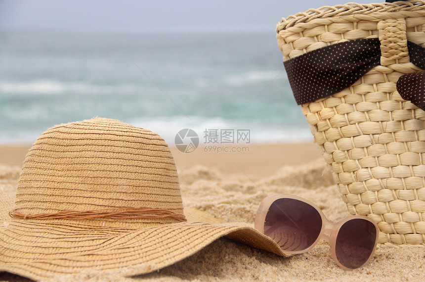 海滩项目稻草配饰太阳镜假期支撑女性蓝色海岸海浪海洋图片