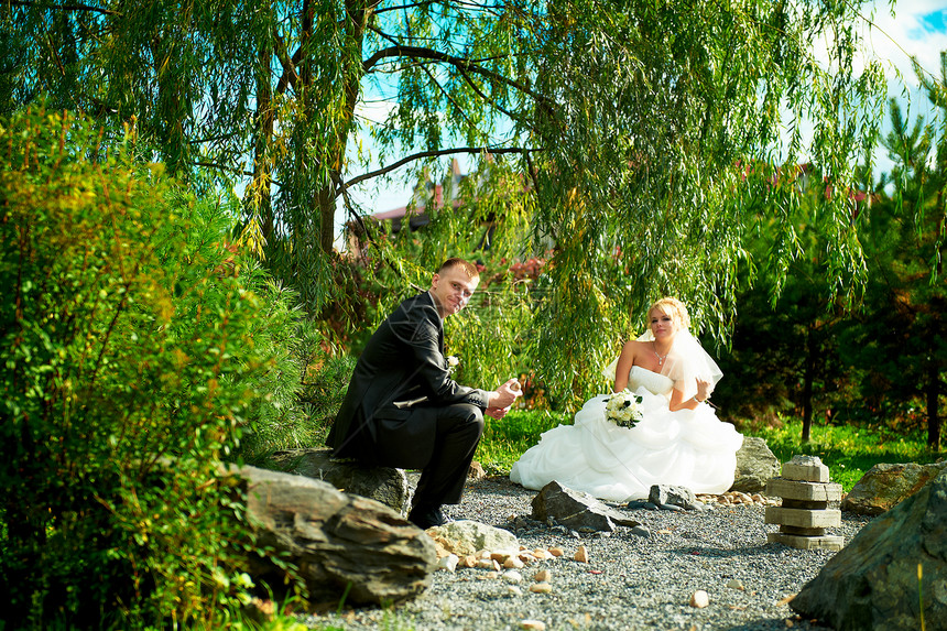 绿色公园背景的新娘和新郎庆典花束微笑婚礼丈夫婚姻夫妻拥抱套装裙子图片