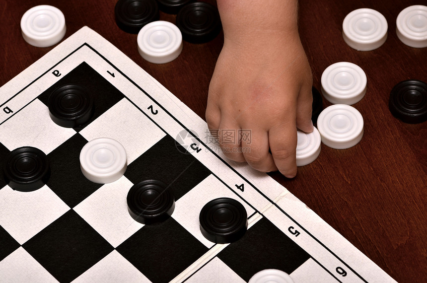 小男孩玩棋牌闲暇对抗逻辑数字战略娱乐运动青年教育跳棋图片