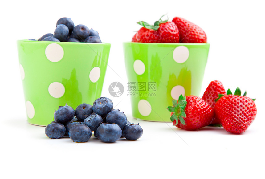 将新鲜果子放在一个绿色的杯子上 在白色的背面黑色活力食物小吃红色蓝色水果甜点浆果图片