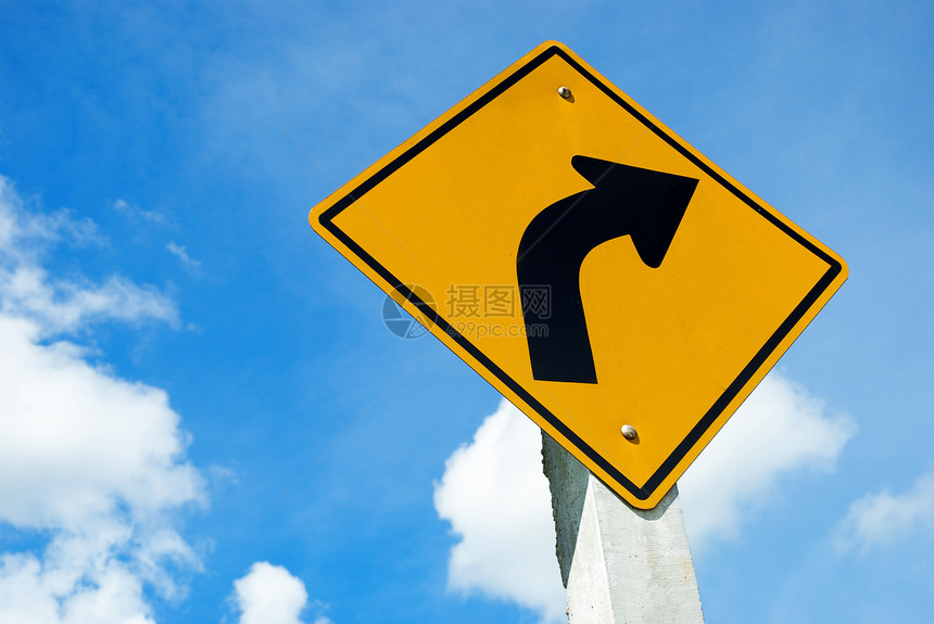 蓝色天空上危险左曲线的公路标志警告图片