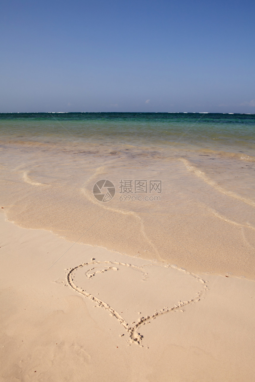 在海滩的沙滩上 心浸入沙土中图片