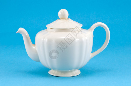 蓝色背景的旧陶瓷白茶壶盘背景图片