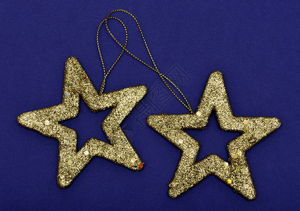 金光闪闪的明星圣诞装饰品 孤立在蓝面包上火花庆典季节性金子饰品蓝色问候语卡片传统星星背景图片