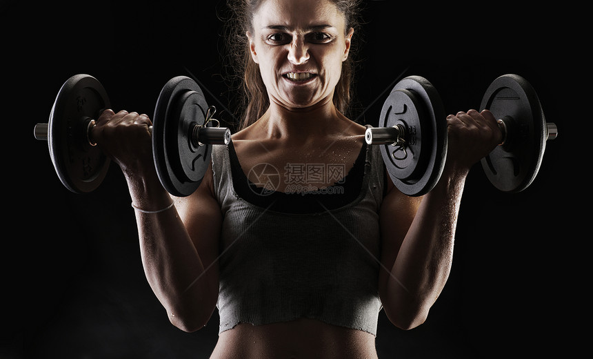 抬起哑铃肌肉教练女士私人身体活动重量热情训练女子图片