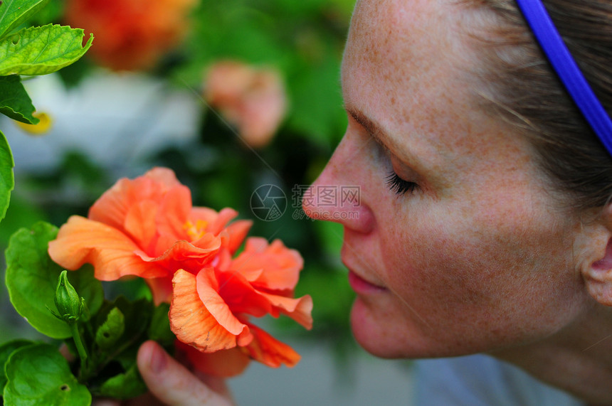 美女闻花香花瓣头巾橙子女士植物花卉香味植物群热带图片