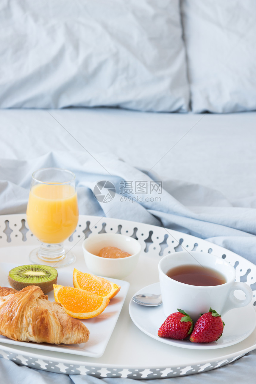 在床上吃着美味早餐的托盘图片