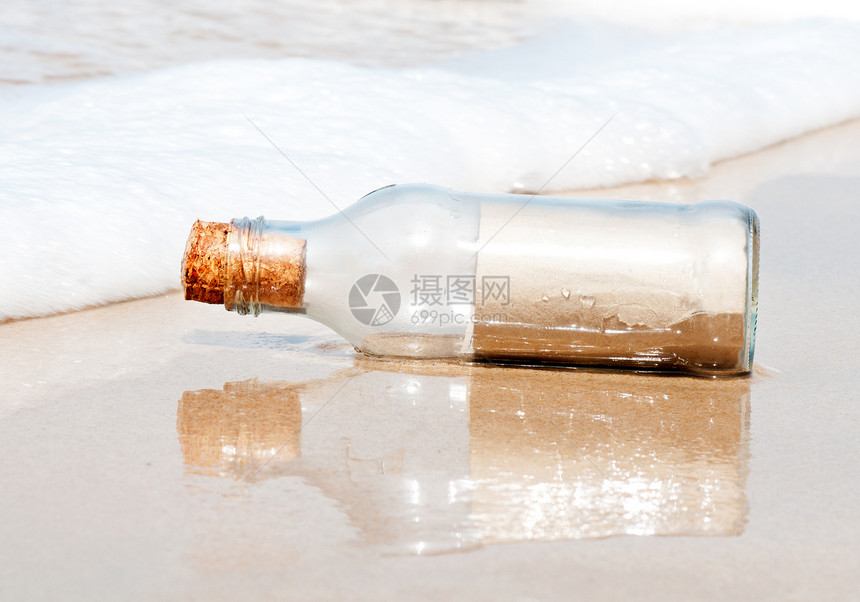 海滩上的玻璃瓶波浪静物棕色概念图片