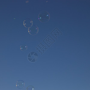 天空中的肥皂气泡孩子们圆形圆圈球形蓝色漂浮乐趣背景图片