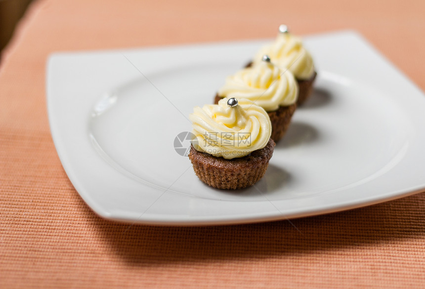 巧克力蛋糕 上面有银色的纸杯片 在白色盘子上美食面包磨砂小雨桌布甜点派对蛋糕奶油黄油图片