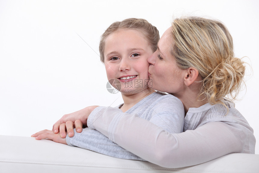母亲亲吻女儿头发乐趣母性美丽投标沙发拥抱童年女孩妈妈图片