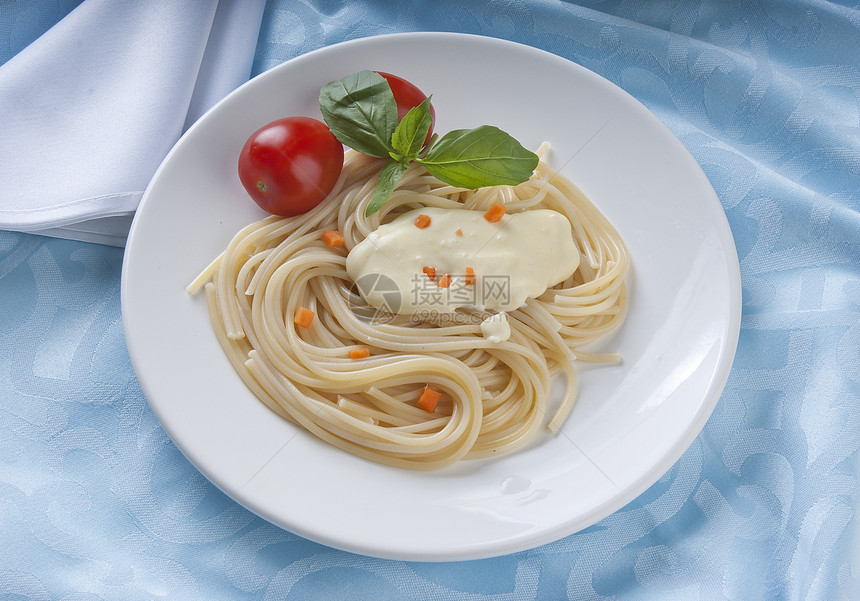 意大利面条蓝色餐巾白色奶油绿色桌布食物盘子图片