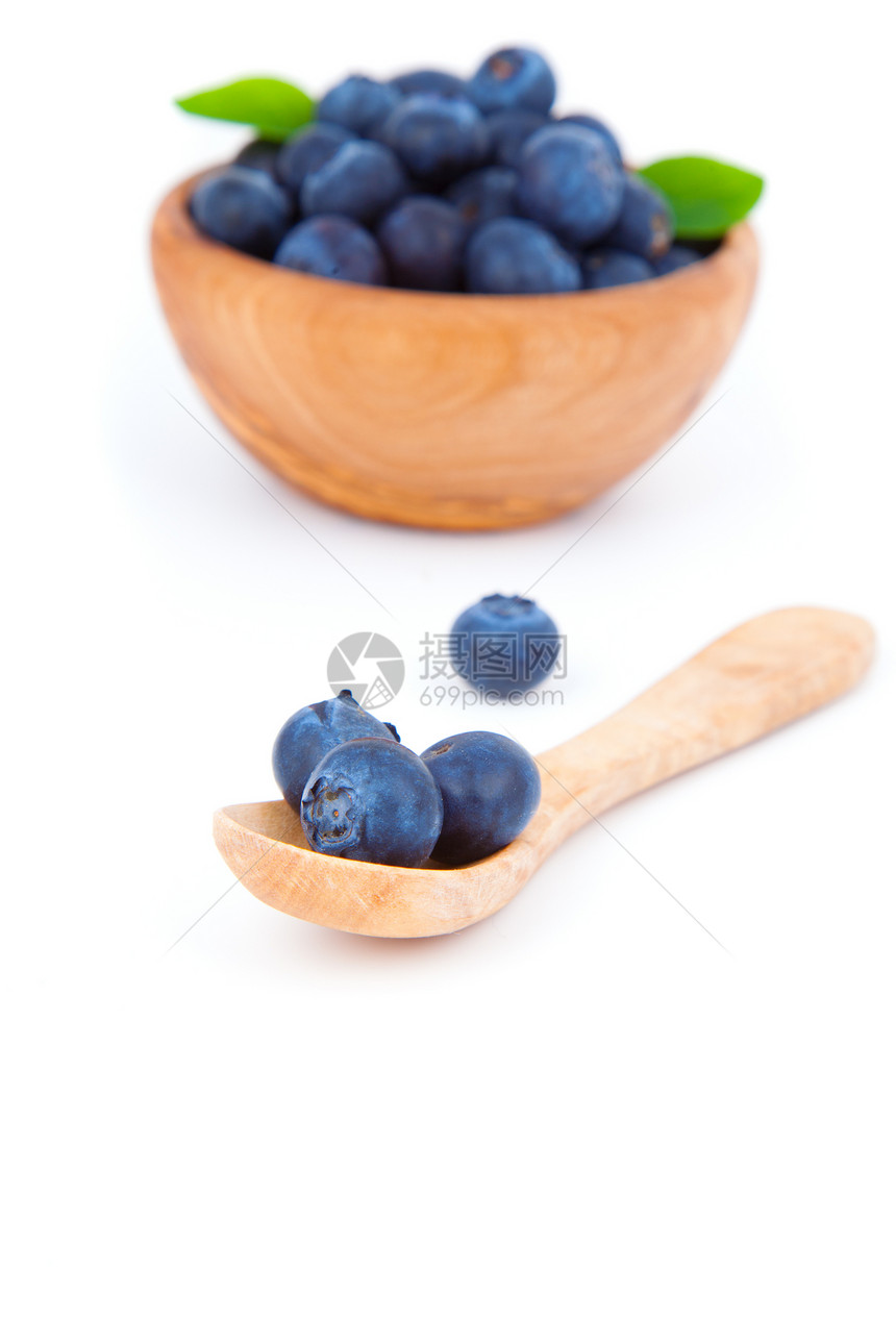 新鲜蓝莓用木勺子 白色背景图片