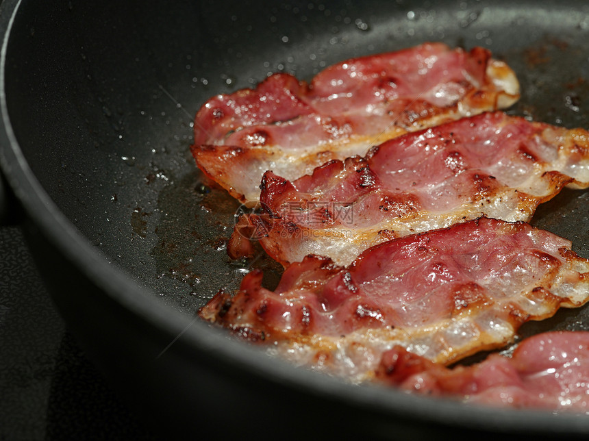 煎培根带子烹饪猪肉煎锅铁板宏观火炉厨房油炸早餐图片