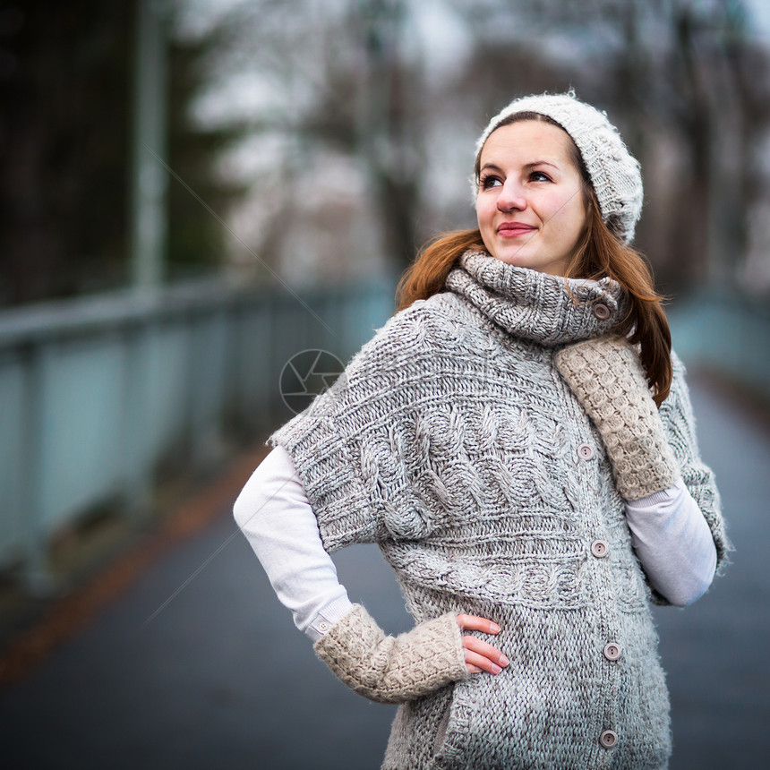 身穿温暖羊毛衣的年轻女子微笑开襟衫羊毛快乐冒充公园季节手套成人树木图片