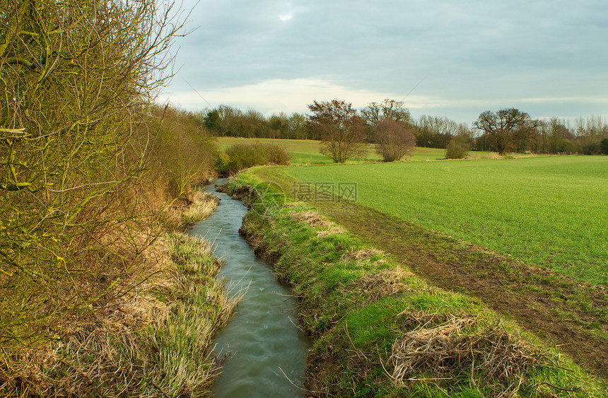 流经英语乡村的河水生活树木季节天空叶子国家蓝色太阳起伏射线图片