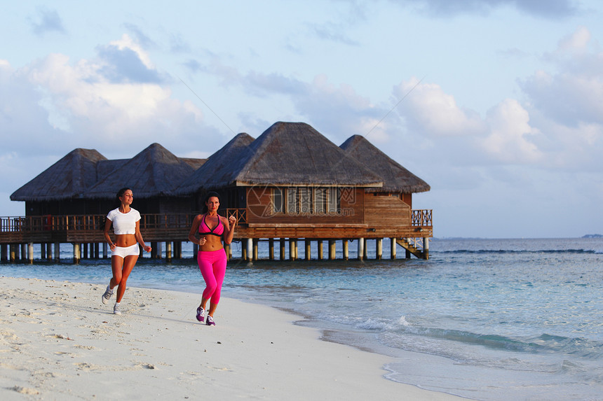 两个女人在沙滩上奔跑运动天空运动装慢跑者赛跑者跑步酒店慢跑训练黑发图片