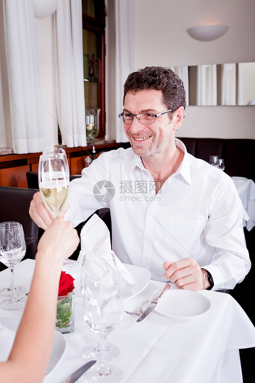 在餐厅欢庆快乐的一对笑着微笑的情侣幸福玻璃酒精周年推介会女士用餐成人浪漫庆典图片