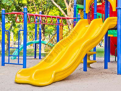 公园的游乐场玩物塑料花园红色绿色孩子乐趣操场黄色金属背景图片