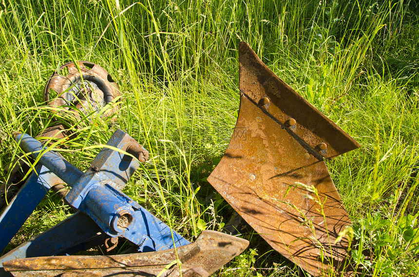 旧式生锈拖拉机在农场的草地上耕种图片