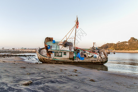 海滩上沉船的Ashwash木头港口海洋钓鱼血管废墟航海损害腐烂支撑背景图片