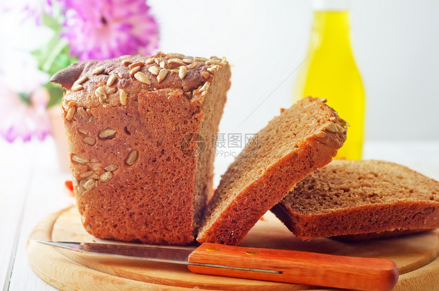 木板上的新鲜面包和刀燕麦乡村面粉小麦纤维营养粮食食物美食饮食图片