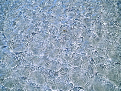 海滩浅水中的海洋波纹支撑游泳晴天海浪海滨天蓝色太阳液体反射阳光背景图片