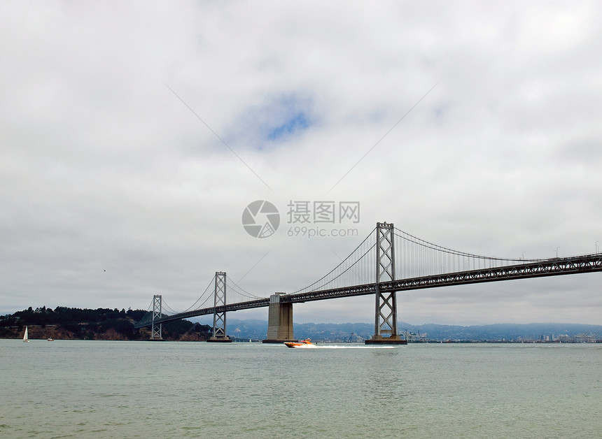 旧金山湾大桥在云天历史性旅行旅游运输汽车天空市中心宝藏交通天际图片