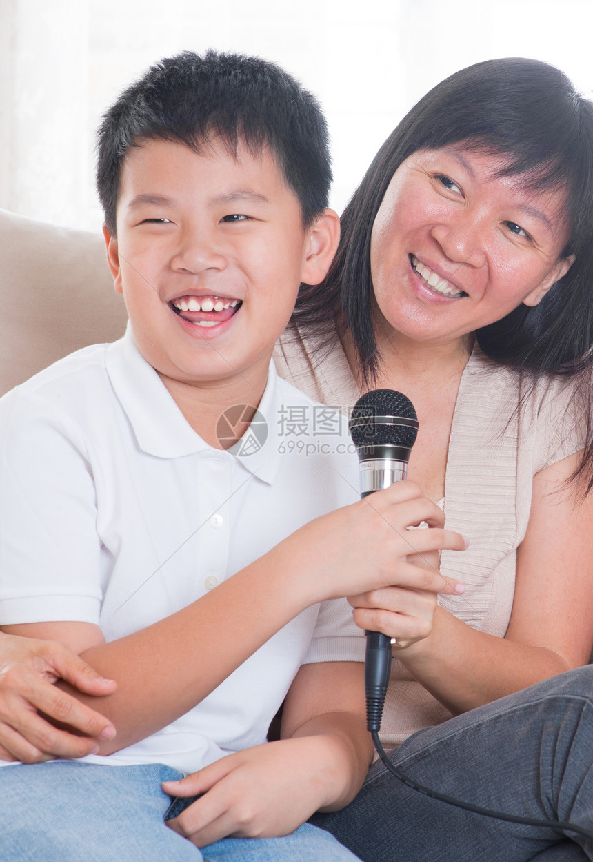亚洲家庭唱卡拉OK乐趣微笑孩子女士女孩沙发麦克风旋律青年儿子图片