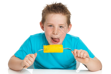 男孩子吃玉米在鳕鱼上食物头发午餐白色黄色盘子小吃饥饿棒子舌头背景图片