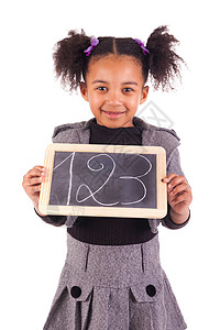 带黑板的非洲年轻女孩学习爆炸幸福女性快乐乐趣婴儿学生微笑黑色背景图片