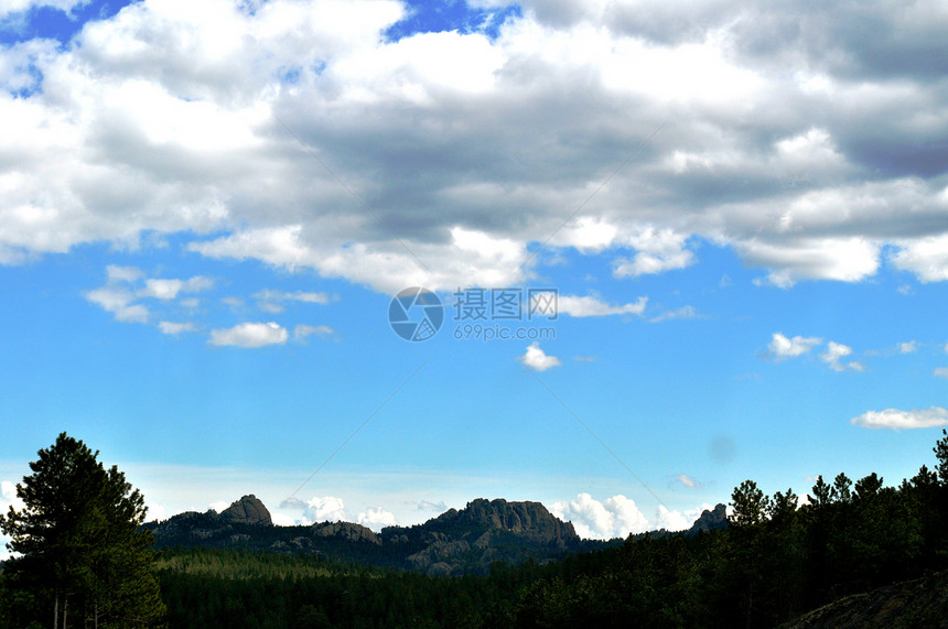 黑山和天空背景蓝色爬坡丘陵山脉树木图片