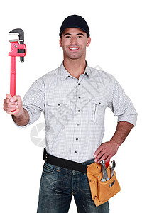 男人用可调节的扳手房子机械工人工作套装管道劳动维修帽子家背景图片
