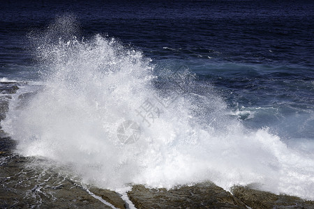 海浪岩石冲撞岩石的海洋海浪天气天空风景破岸环境海滩阳光碰撞蓝色海岸背景