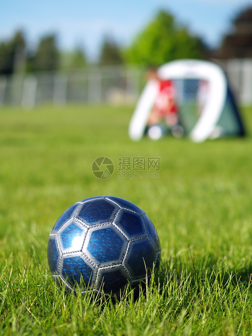 蓝足球球和玩家闲暇竞争乐趣跑步分数草地游戏场地团队竞赛图片