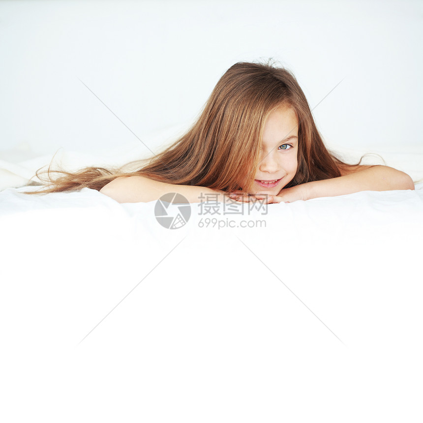 女孩在床上快乐闲暇毯子微笑女儿童年唤醒乐趣卧室苗圃图片