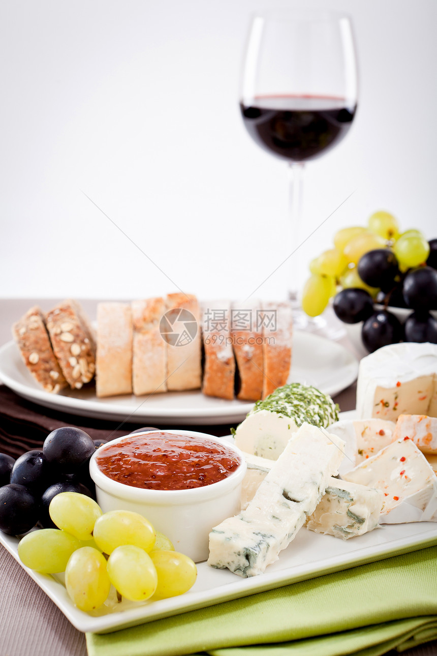 奶酪盘加葡萄和红酒晚宴木头桌子产品木板食物玻璃美食熟食奶制品小吃图片