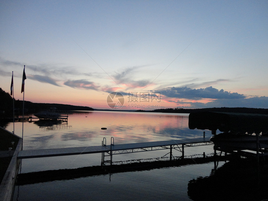 日落在湖上夕阳反射船库码头天空船荫阴影旗杆图片