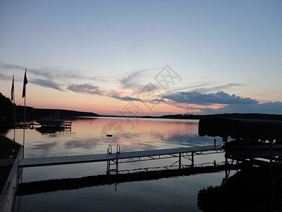 桑德贝日落在湖上夕阳反射船库码头天空船荫阴影旗杆背景