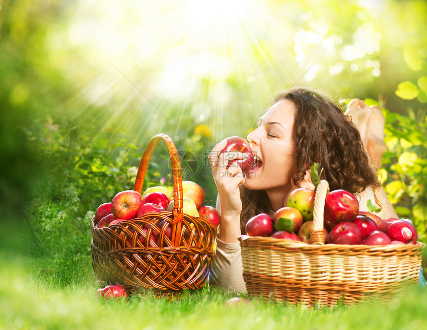 果园中吃有机苹果的美丽女孩饮食收集水果篮子晴天采摘太阳花园乐趣活动图片