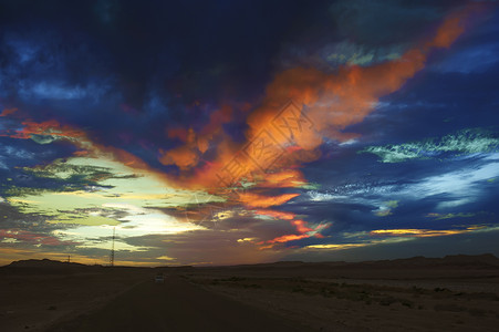 在撒哈拉沙漠上闪耀着彩色的白日黑云辉光晚霞天空沙漠背景图片