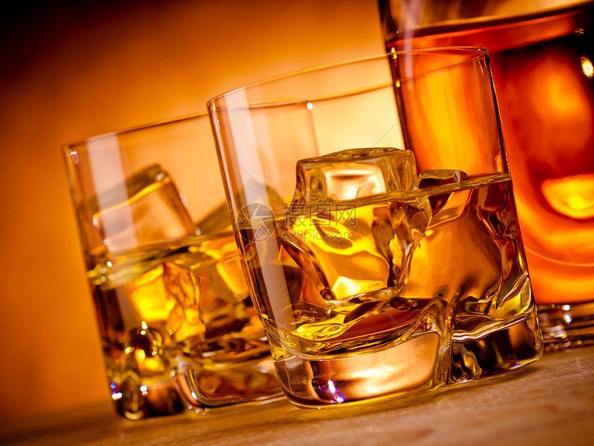 两杯威士忌和一瓶酒红色瓶子不倒翁饮料冰块岩石玻璃黄色图片