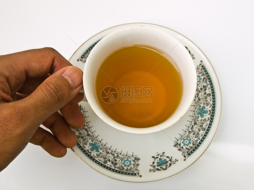 用手握着的茶杯 用花纹 将它与Whit隔离开来玻璃草本杯子棕色时间早餐饮料盘子白色液体图片