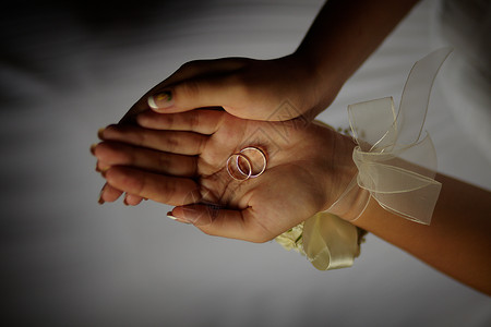 结婚戒指婚礼金子优雅花束阴影美甲新娘已婚手指新人背景图片
