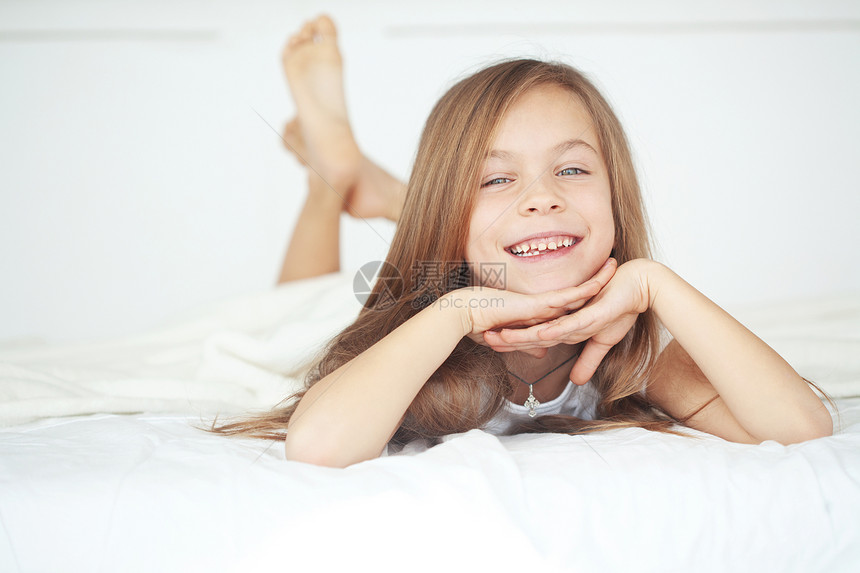 女孩在床上寝具闲暇孩子微笑房间乐趣后代童年唤醒卧室图片