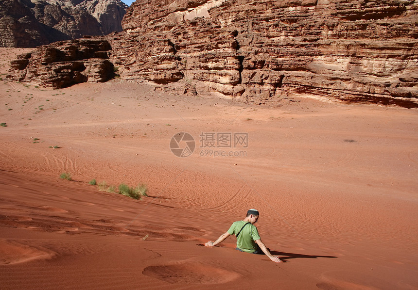 一名西方游客正在瓦迪鲁姆的沙丘上翻滚图片