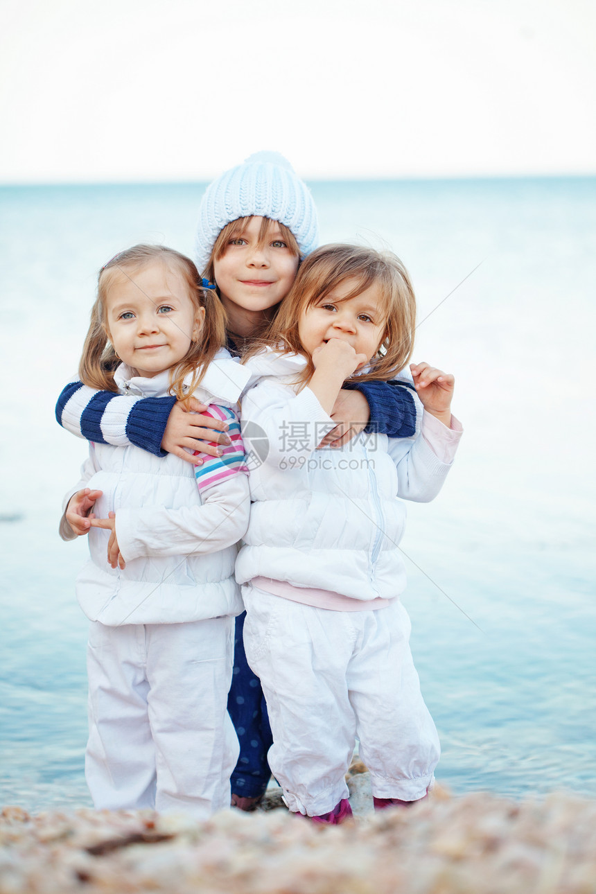 海滩上的孩子团体拥抱闲暇朋友们衣服孩子们童年游戏友谊青年图片