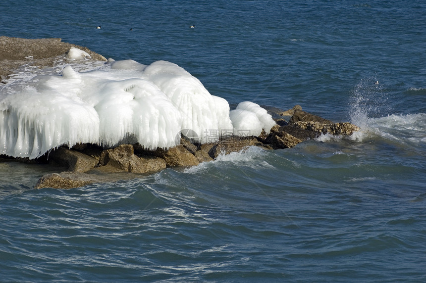 冰岛岩石日落石头飞溅蓝色阳光照射海浪海滩图片