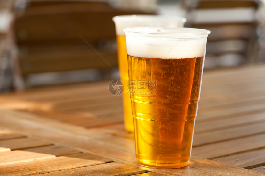 站在木制桌上的啤酒花园泡沫金子琥珀色庆典托盘桌子酒精玻璃液体图片