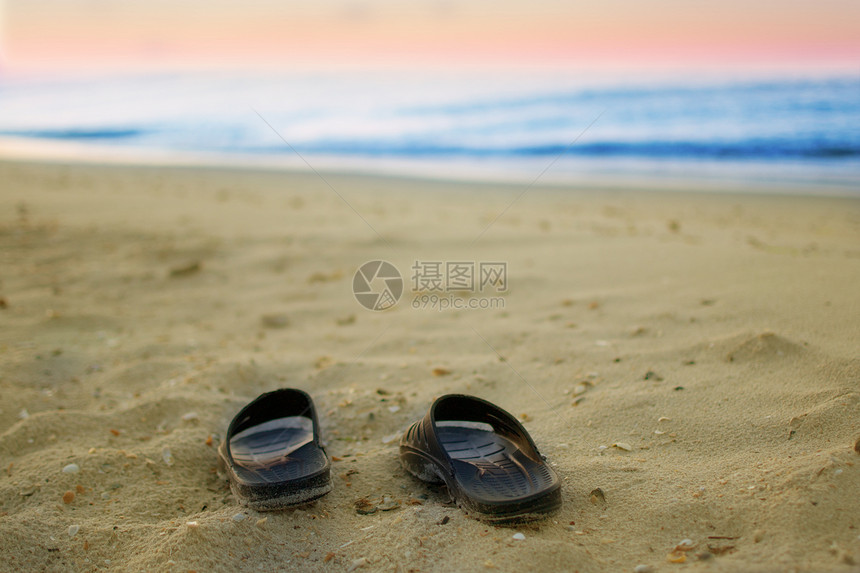 沙滩上的运动鞋海洋支撑假期海岸线阳光海岸水平海浪拖鞋游客图片